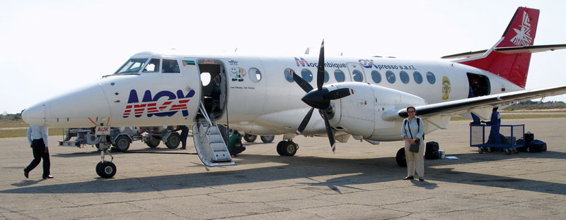 Jacqueline Serrao stands on the tarmac in front of a Mozambique Express plane